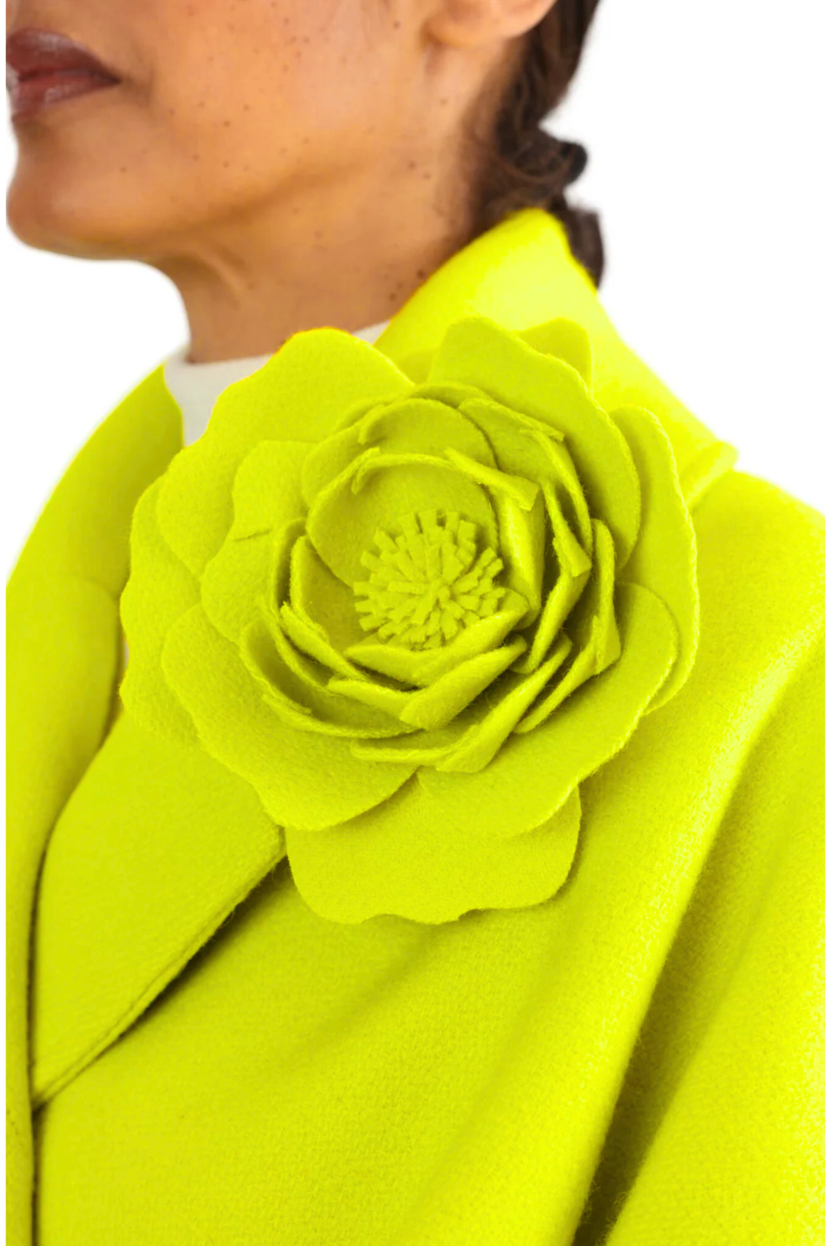 Large chartreuse yellow wool felt peony brooch on same colour wool coat lapel