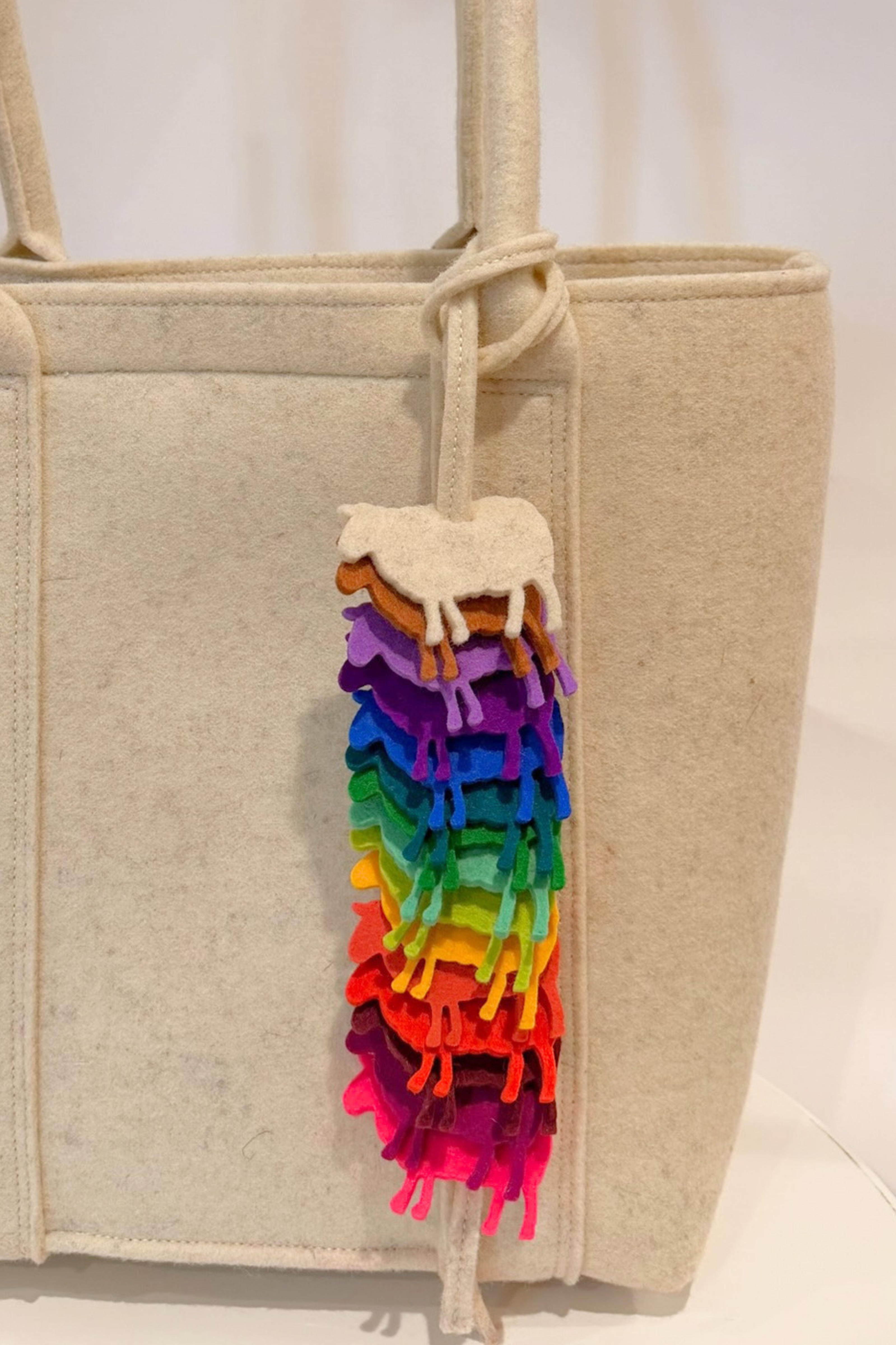 Many colourful sheep shaped wool charms hanging from wool bag