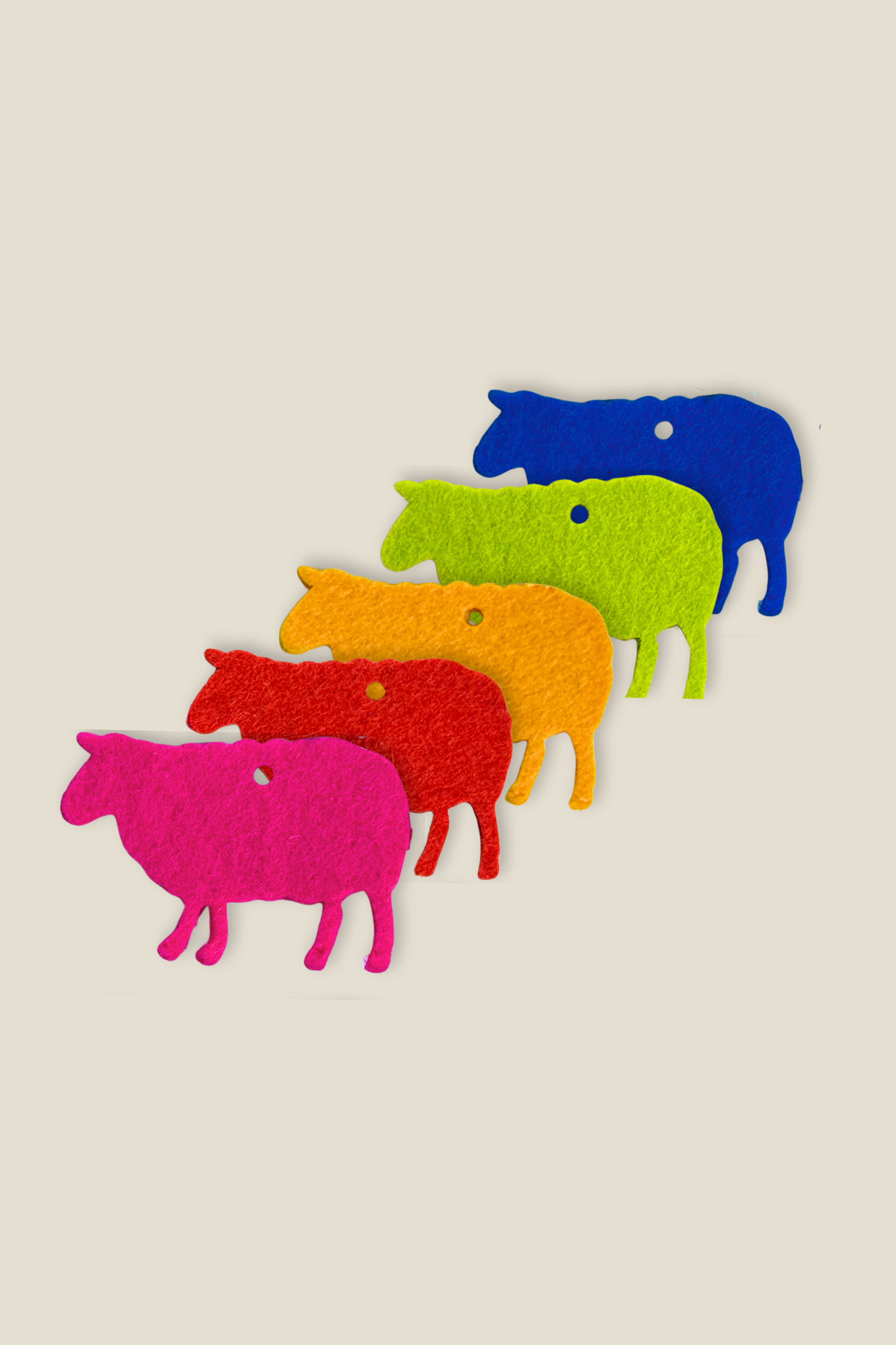 Five colorful wool felt sheep cutouts in pink, red, orange, green, and blue, arranged diagonally on a light beige background.