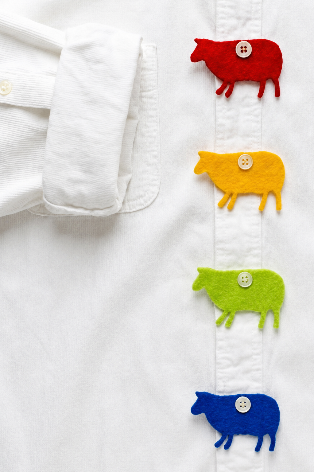 Sheep charms attached to buttons on white dress shirt